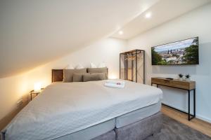 a bedroom with a large white bed and a tv at Apartment Milse - Modern. Stylisch in Bielefeld