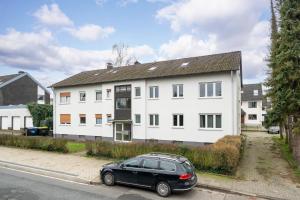a black car parked in front of a white house at Apartment Milse - Modern. Stylisch in Bielefeld