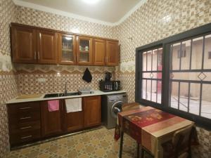 een keuken met houten kasten, een wastafel en een fornuis bij BARAKAH ESTATE APARTMENTS in Sere Kunda