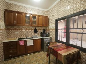 a kitchen with wooden cabinets and a sink and a stove at BARAKAH ESTATE APARTMENTS in Sere Kunda