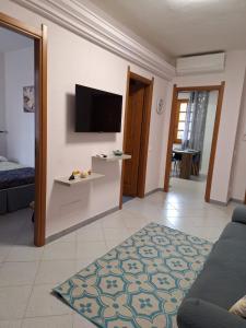 un salon avec une télévision à écran plat sur un mur dans l'établissement Tasinanta casa vacanze, à Santa Luria