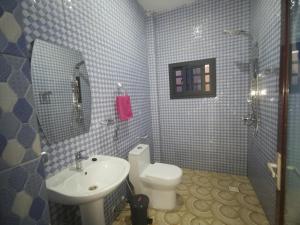 a bathroom with a white toilet and a sink at BARAKAH ESTATE APARTMENTS in Sere Kunda +20 photos