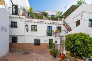 un edificio bianco con balconi e piante in vaso di Traditional central 2 dbl bed apt in quiet square a Benalmádena