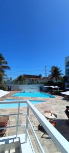 a swimming pool with chairs and a table next to it at Beira-Mar flat 310 Ponta Negra Beach in Natal