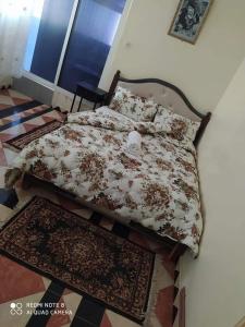 a bedroom with a bed with rugs on the floor at Guest House Zaida in Zeïda