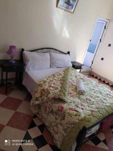 a bedroom with a bed with a quilt on it at Guest House Zaida in Zeïda