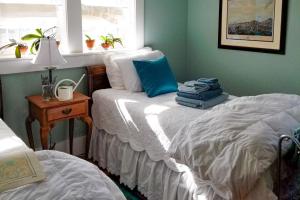 1 dormitorio con 2 camas individuales y ventana en Full of Light Cottage, en Rockland