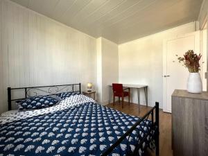 ein Schlafzimmer mit einem Bett und einem Tisch mit einer Vase in der Unterkunft Le Panorama d'Avon - 10' Gare in Avon