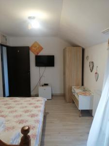 a bedroom with a bed and a tv on the wall at Casa Nobilis in Gura Humorului