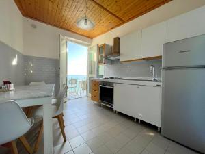cocina con nevera y mesa con sillas en Families or Groups 3 Terrazzi Apartment on Sea en Vernazza