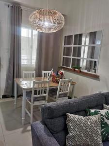 een woonkamer met een bank en een tafel en stoelen bij 2BR Penthouse in Brixton Place with breathtaking view of BGC in Manilla