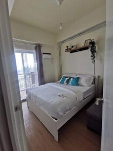 een slaapkamer met een groot wit bed en een raam bij 2BR Penthouse in Brixton Place with breathtaking view of BGC in Manilla