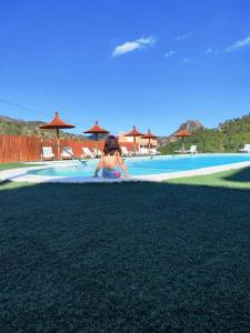 a woman in a bikini laying on the ground next to a swimming pool at Casa Rural Puente del S,egura G in Elche de la Sierra