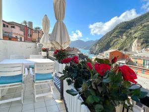 d'un balcon avec une table, des chaises et des roses. dans l'établissement Families or Groups 3 Terrazzi Apartment on Sea, à Vernazza