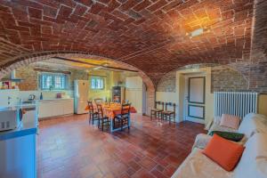 a kitchen and living room with a brick wall at Serra Alta Langa Holiday Home in Trezzo Tinella +45 photos