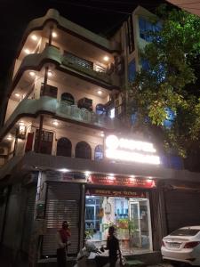 un edificio con gente de pie fuera de él por la noche en Hotel moon place, en Lucknow