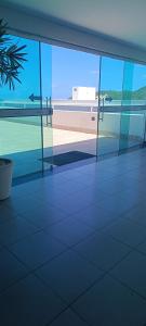 an empty building with a view of the beach through glass at Beira-Mar flat 310 Ponta Negra Beach in Natal