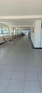 an empty hallway with tables and chairs in a building at Beira-Mar flat 310 Ponta Negra Beach in Natal