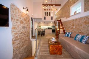 a living room with a couch and a stone wall at Casa Christina-Luxury Villa in Kissamos