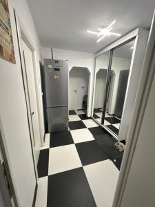 corridoio con frigorifero e pavimento a scacchi di Apartament Sorin a Tulcea