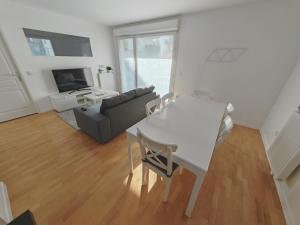 ein Wohnzimmer mit einem weißen Tisch und einem Sofa in der Unterkunft Paris 15 min Appartement tout confort 6 couchages in Vitry-sur-Seine