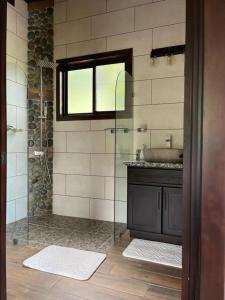 uma casa de banho com uma cabina de duche em vidro e um lavatório. em Finca Waca em San Pablo