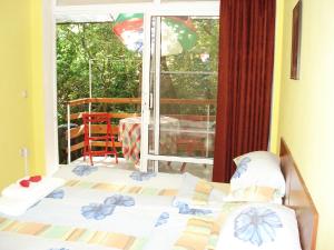a bedroom with two beds and a balcony with a table at Villa Exotica in Balchik