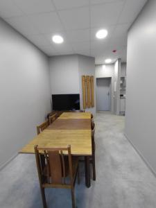 a conference room with a wooden table and chairs at Hostel PLUNKSA in Marijampolė