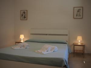 1 dormitorio con 1 cama con 2 toallas en Asfodelo 97, en Alghero