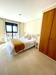 ein Schlafzimmer mit einem Bett und einem großen Fenster in der Unterkunft Sea View Apartment Sabbia by Gabbeach in Valencia