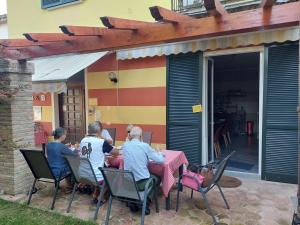 a group of people sitting at a table on a patio at B&B CountryHouseAnna in Crema