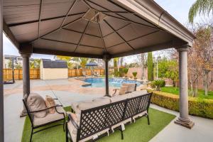 a swing under a large umbrella on a patio at Spacious Clovis Vacation Rental with Outdoor Oasis! in Clovis
