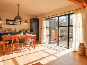a kitchen with a table and chairs and a large sliding glass door at Church Farm Dairy in Exeter