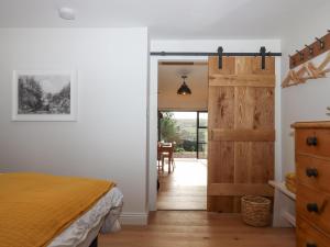 a bedroom with a bed and a sliding door at Church Farm Dairy in Exeter