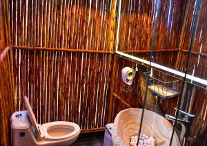 La salle de bains est pourvue de toilettes et d'un mur en bois. dans l'établissement Omghat Glamping - Domo Ganesha, à El Peñol