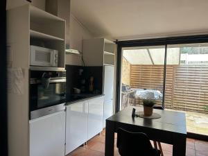 a kitchen with a table and a microwave oven at Maisonzen in Pugnac