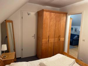 a bedroom with a wooden cabinet next to a bed at Wohnung 225 mit Ostseeblick in Ostseebad Koserow