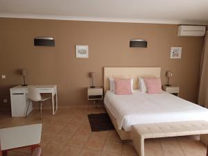 a bedroom with a large bed with pink pillows at Costamar in Lagos