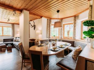 a dining room and living room with a wooden ceiling at Barney L in Rauris