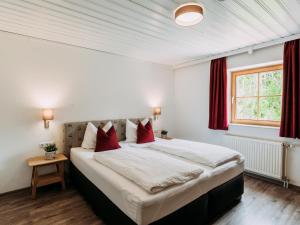 a bedroom with a large bed with red pillows at Barney L in Rauris