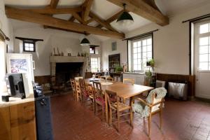 Saint-Étienne-de-CorcouéにあるLa maison Benastreの木製のテーブルと椅子のあるキッチンとダイニングルーム