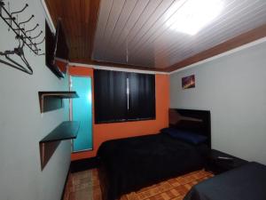 a small room with a bed and a window at Habitaciones con baño privada Quiroga in Bogotá