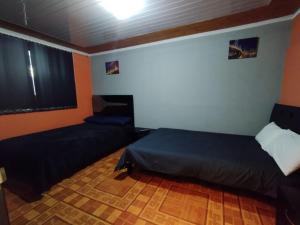 a bedroom with a bed and a couch and a window at Habitaciones con baño privada Quiroga in Bogotá