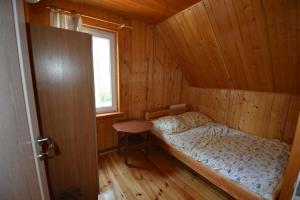 Pobierowo Dom 100m2 z działką في بوبيروفو: سرير صغير في غرفة خشبية مع نافذة