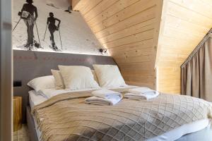 1 dormitorio con 1 cama con toallas en Domki na Gawlakach, en Zakopane