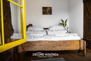 プシビツにあるZielone Wzgórza - Hobbitowe Domki na Kaszubachの鏡付きの部屋のベッド1台