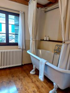 La salle de bains est pourvue d'une baignoire blanche et d'une fenêtre. dans l'établissement Foresteria Di Villa Tiepolo Passi, à Trévise