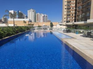 a large swimming pool with blue water in a city at Lindo Apartamento dentro do Shopping in Águas Claras