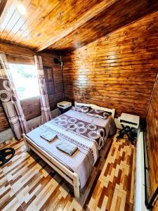 1 dormitorio con 1 cama en una habitación de madera en Cabaña El Forastero en Coronel Moldes