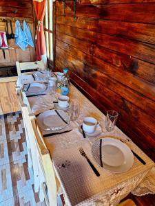 una mesa con platos y platos en una habitación en Cabaña El Forastero en Coronel Moldes